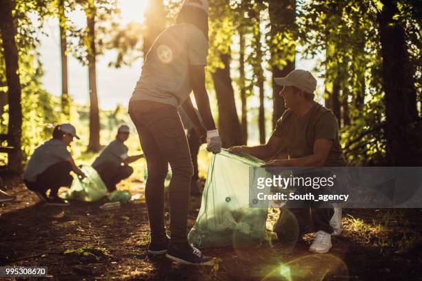 Group of people with garbage bags cleaning public park