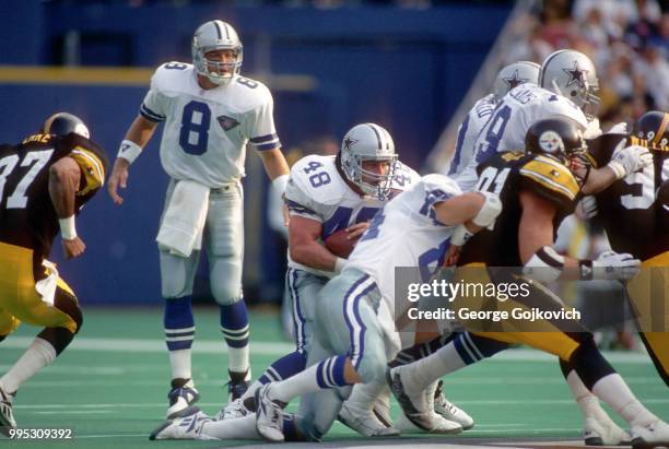 Fullback Daryl Johnston of the Dallas Cowboys runs with the football behind the blocking of tight end Jay Novacek after taking a handoff from...