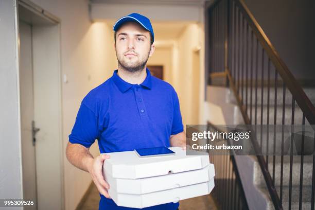 delivery boy bringing pizza - pizza delivery stock pictures, royalty-free photos & images