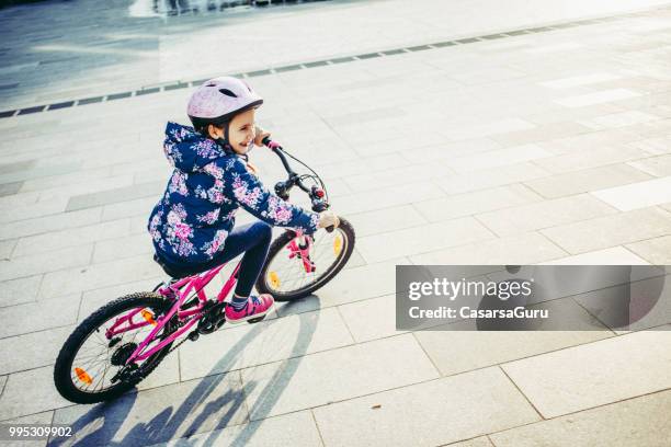 Young Girl Enjoying Riding Bicycle on Town Square