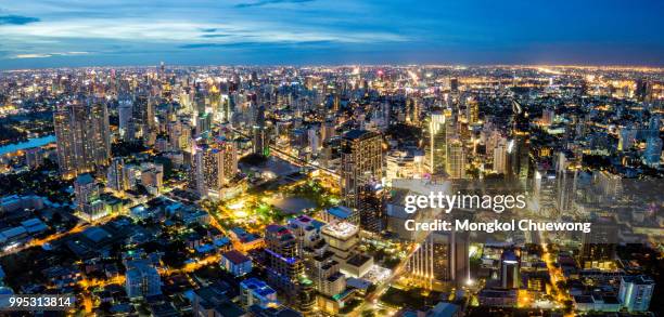 aerial view of bangkok skyline and skyscraper on sukhumvit center of business in capital. panorama of modern city and bts skytrain with benjasiri park on asoke junction in bangkok thailand at night - silom foto e immagini stock