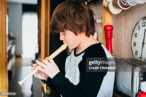 close up of a boy playing the flute - flauto foto e immagini stock