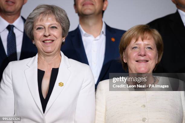 Prime Minister Theresa May and German Chancellor Angela Merkel take part in the family photo during the second day of Western Balkans summit at...