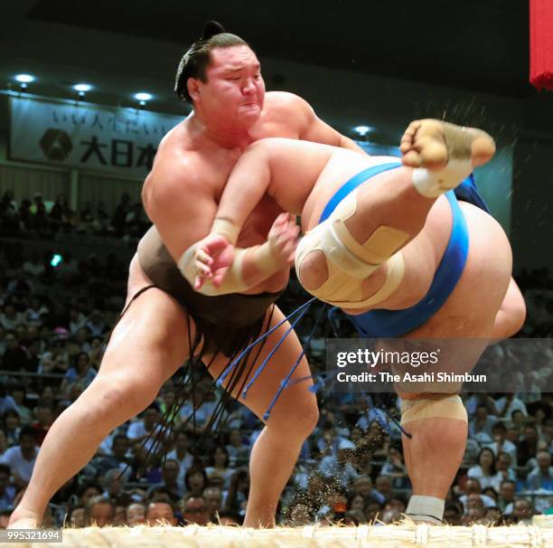 Mongolian yokozuna Hakuho throws Kotoshogiku to win on day three of the Grand Sumo Nagoya Tournament at the Dolphin's Arena on July 10, 2018 in...