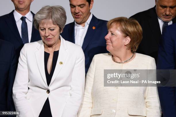 Prime Minister Theresa May and German Chancellor Angela Merkel take part in the family photo during the second day of Western Balkans summit at...