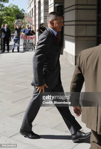 Michael Flynn, former U.S. National security advisor, passes in front of demonstrators while arriving for a status hearing at federal court in...