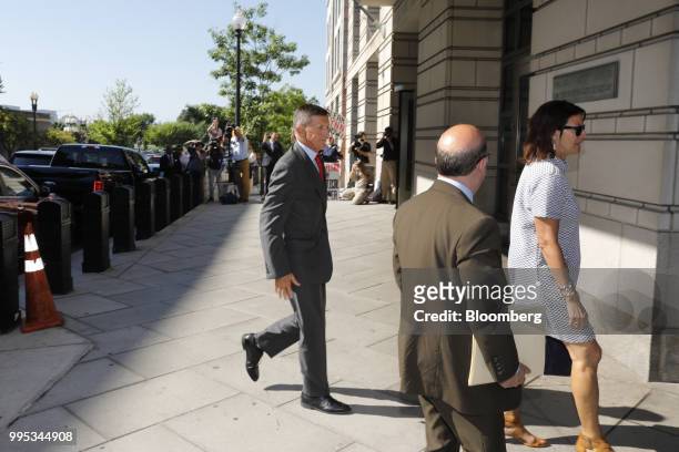 Michael Flynn, former U.S. National security advisor, left, passes in front of demonstrators and members of the media while arriving for a status...