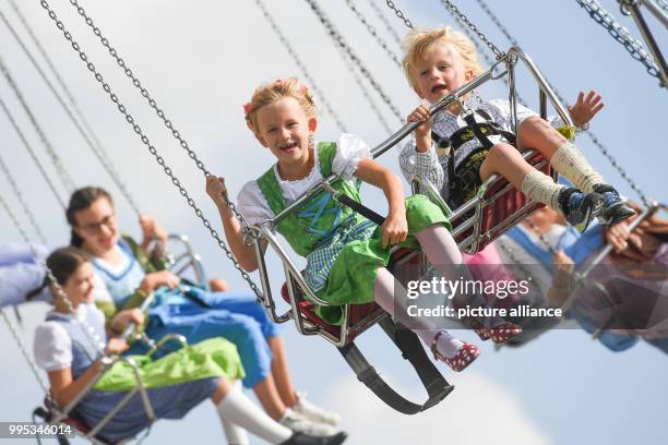 Visitors ride on a swing carousel at the Theresienwiese fair the Bavarian Oktoberfest beer festival in Munich, Germany, 24 September 2017. Photo:...