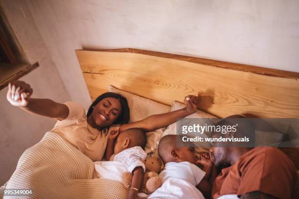 parents with little children in bed waking up from nap - 12 23 months stock pictures, royalty-free photos & images