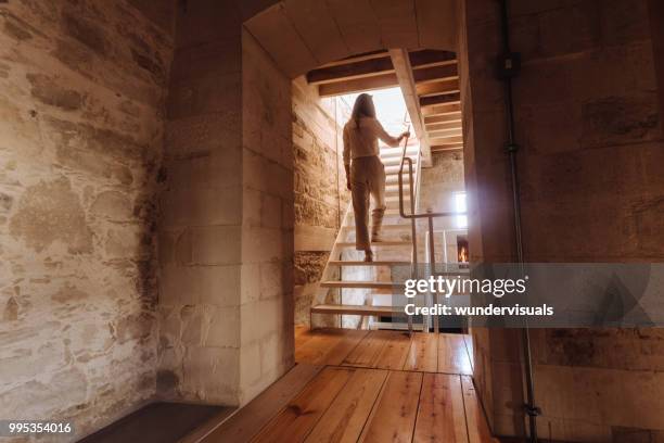 woman ascending wooden staircase in modern architecture rustic house - heritage hall stock pictures, royalty-free photos & images