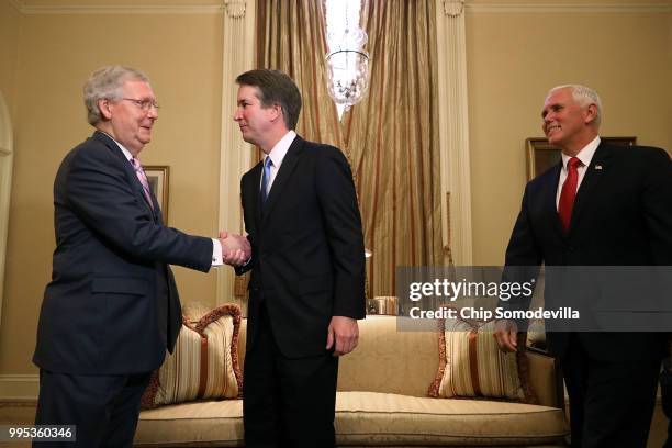 Senate Majority Leader Mitch McConnell shakes hands with Judge Brett Kavanaugh as he arrives with Vice President Mike Pence before a meeting in...