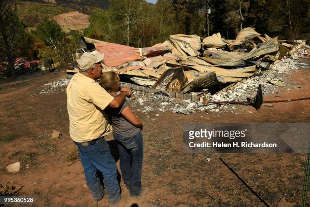 Larry Morgan and his daughter Tami Morgan look at what is left of their home at the bottom of La Veta Pass on July 9, 2018 in La Veta, Colorado. The...