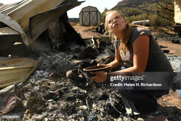 Tami Morgan looks up towards her father Larry Morgan, right, as she carefully sifts through what used to be the front entrance of her family home at...