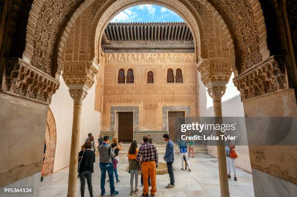 Tourists in the Patio of the Gilded Room at the Alhambra, a 13th century Moorish palace complex in Granada, Spain. Built on Roman ruins, the Alhambra...