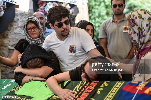 Misra Oz mother of Oguz Arda Sel victim of a train accident, and a relative, mourn on his coffin on July 10, 2018 during a funeral ceremony at...