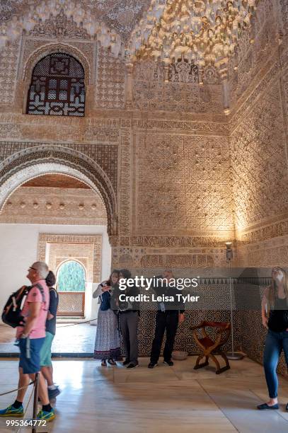 Tourists in the Sala de dos Hermanas, Hall of the two Sisters, at the Alhambra, a 13th century Moorish palace complex in Granada, Spain. Built on...