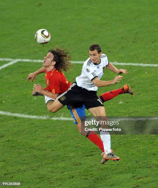 Miroslav Klose of Germany battles with Carlos Puyol of Spain during the FIFA World Cup Semi Final at the Moses Mabhida Stadium on July 7, 2010 in...