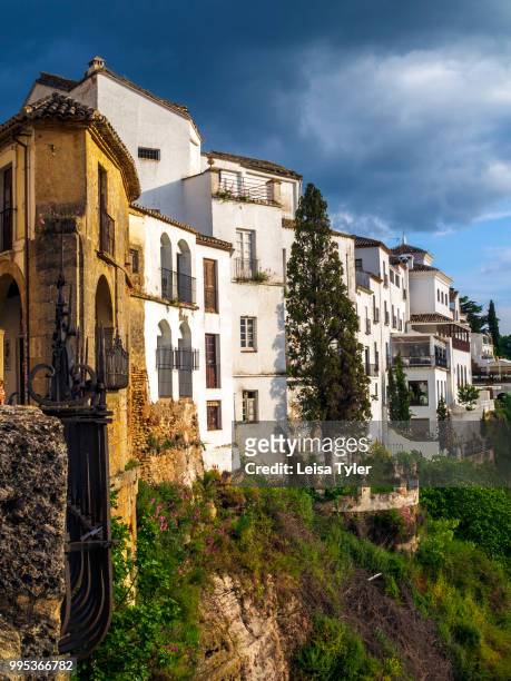 Storm brews over houses lining the El Tajo Gorge in Ronda, a heritage town and popular tourist destination in Andalusia, Spain.