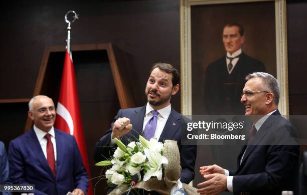 Berat Albayrak, Turkey's treasury and finance minister, center, speaks during a handover ceremony with Naci Agbal, outgoing Turkish finance minister,...