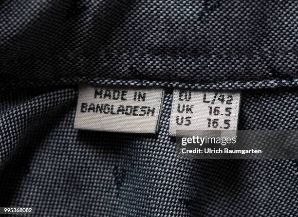 Cheap clothes, made in the third world under inhumane conditions. The photo shows patches with lettering Made in Bangladesh in a garment.