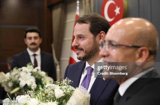 Berat Albayrak, Turkey's treasury and finance minister, center, and Mehmet Simsek, Turkey's former deputy prime minister, right, attend a handover...