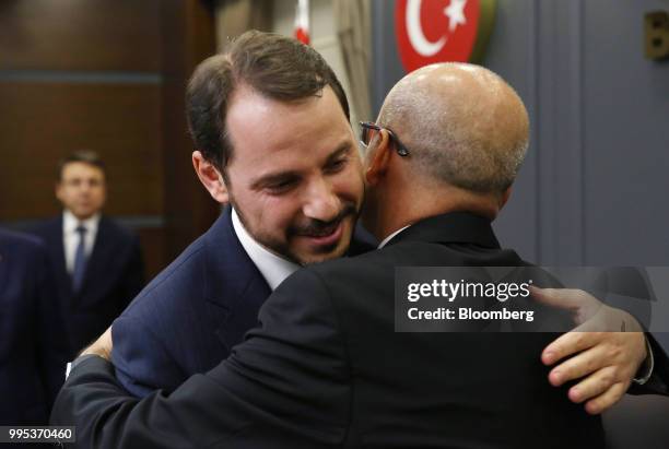 Berat Albayrak, Turkey's treasury and finance minister, left, hugs Mehmet Simsek, Turkey's former deputy prime minister, during a handover ceremony...