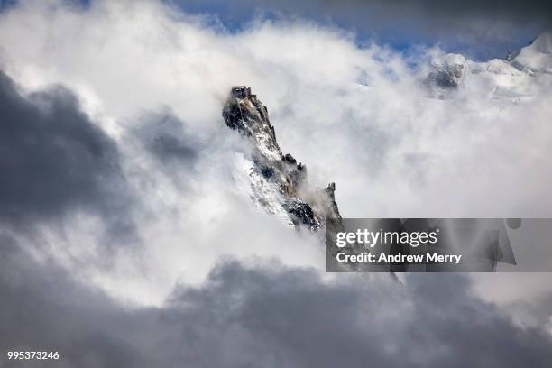 aiguille du midi summit, peak partially obscured by dramatic clouds - torenspits stockfoto's en -beelden