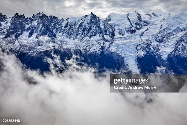 french alps mountain range with snow line. mont blanc summit, peak and glaciers with clouds in valley and overcast sky - pinnacle imagens e fotografias de stock