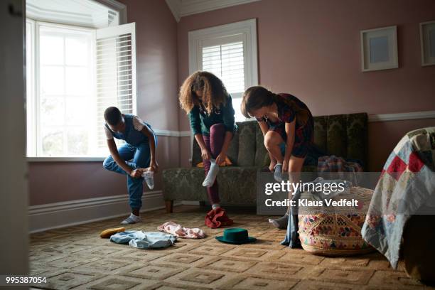 tween girls trying clothes and putting on socks, at home - kids mess carpet stock pictures, royalty-free photos & images