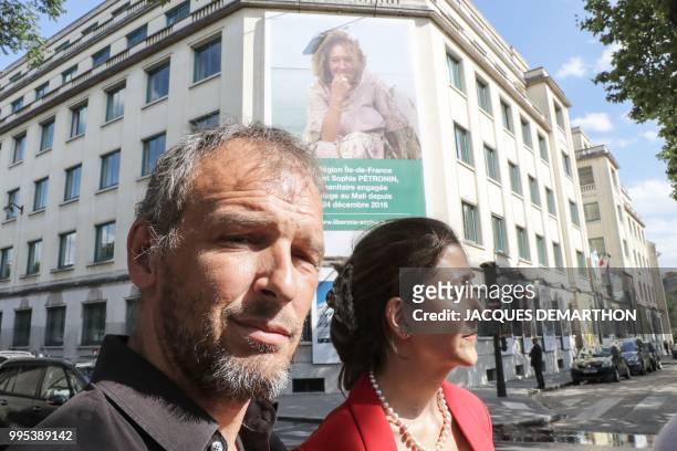 Sophie Petronin's son Stephane Chabaud-Petronin and former FARC hostage Ingrid Betancourt are pictured in front of a giant banner displayed on July...