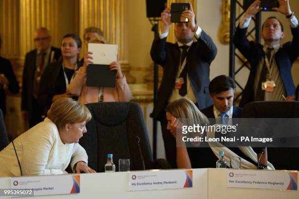 Germany's Chancellor Angela Merkel and Vice-President of the EU Commission Federica Mogherini speak as they attend a plenary session during the...