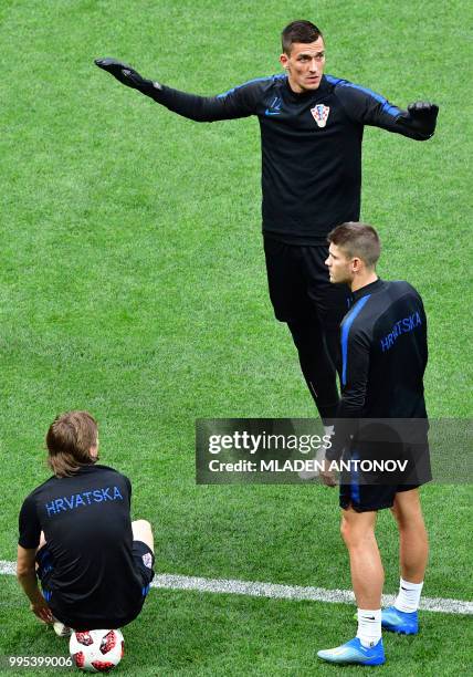 Croatia's midfielder Luka Modric sits on a ball as Croatia's goalkeeper Lovre Kalinic warms up during a training session at the Luzhniki Stadium in...