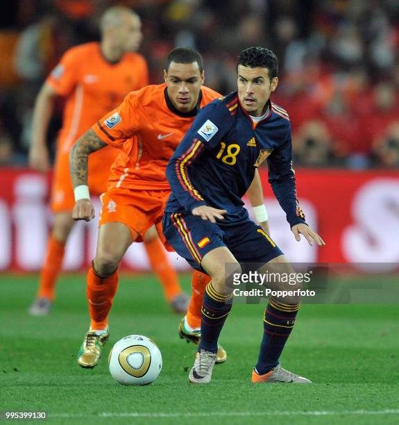Pedro of Spain looks to get away from Gregory van der Wiel of the Netherlands during the FIFA World Cup Final at the Soccer City Stadium on July 11,...