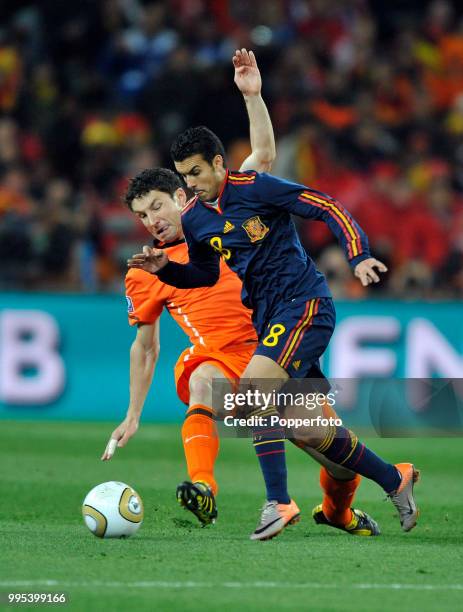 Mark van Bommel of the Netherlands attempts to tackle Pedro of Spain during the FIFA World Cup Final at the Soccer City Stadium on July 11, 2010 in...