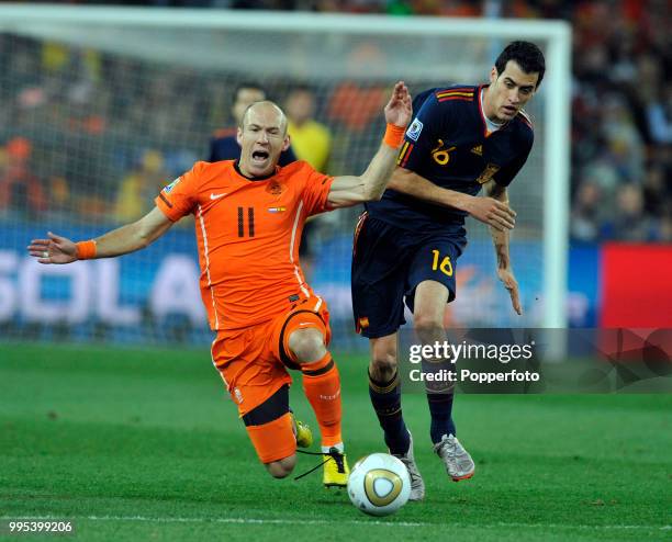 Arjen Robben of the Netherlands is challenged by Sergio Busquets of Spain during the FIFA World Cup Final at the Soccer City Stadium on July 11, 2010...