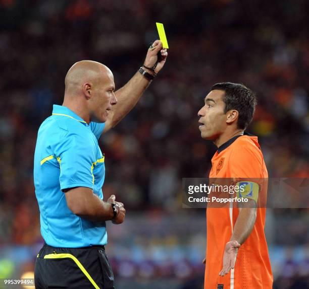 Referee Howard Webb shows the yellow card to Giovanni van Bronckhorst of the Netherlands during the FIFA World Cup Final between the Netherlands and...
