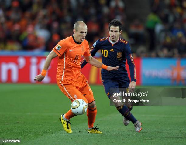 Arjen Robben of the Netherlands is put under pressure by Cesc Fabregas of Spain during the FIFA World Cup Final at the Soccer City Stadium on July...