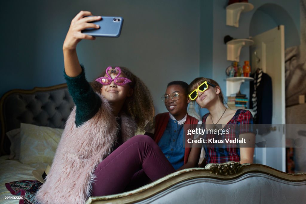 Girlfriends making selfie and wearing weird, funny glasses