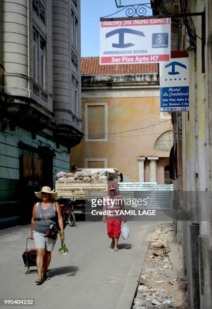 People walk past a house with a sign advertising a private room for rent in Havana, on June 10, 2018. Cuba gave Tuesday a new green light to private...
