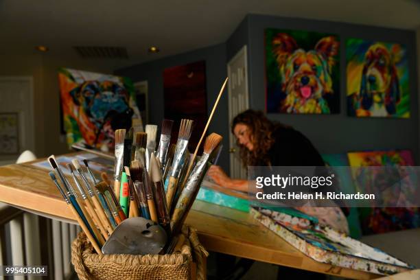 Artist Tif Choate paints a portrait of a dog named Divine in her home studio on July 1, 2018 in Lafayette, Colorado. The smallest size that she works...