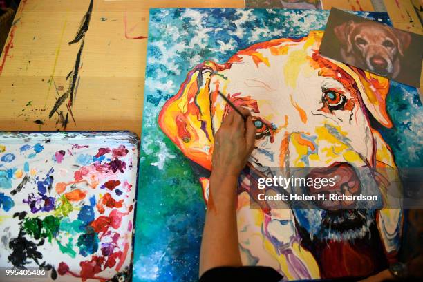 Artist Tif Choate paints a portrait of a dog named Divine in her home studio on July 1, 2018 in Lafayette, Colorado. The smallest size that she works...