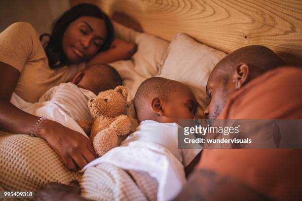 family with two children sleeping together in bed - 12 23 months stock pictures, royalty-free photos & images
