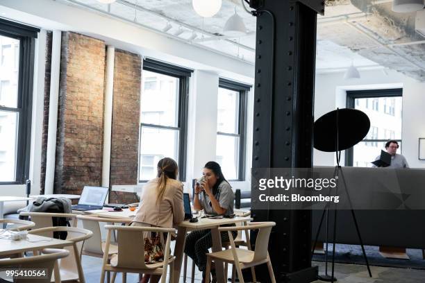 Members sit at a table at the Convene workspace flagship location in New York, U.S., on Monday, July 2, 2018. Convene, a New York-based real estate...