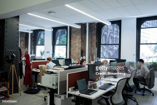 Members work at desks at the Convene workspace flagship location in New York, U.S., on Monday, July 2, 2018. Convene, a New York-based real estate...