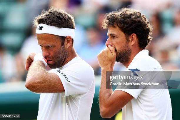 Robin Haase of the Netherlands and Robert Lindstedt of Sweden talk tactics against Dominic Inglot of Great Britain and Franko Skugor of Croatia...