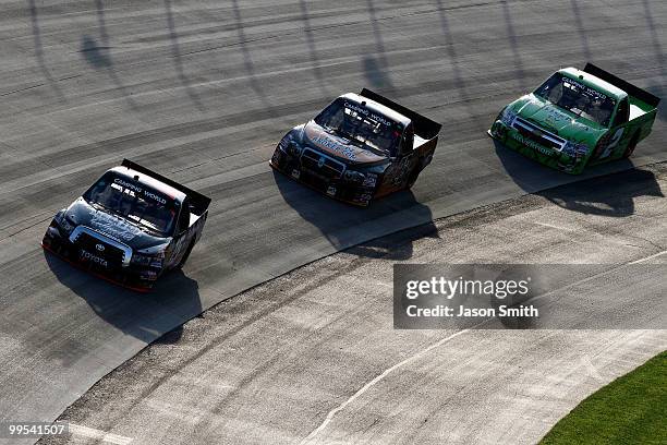 Johnny Benson drives the Red Top Auto Collector Toyota ahead of Jason White, driver of the GunBroker.com Dodge, and Elliott Sadler, driver of the 2...