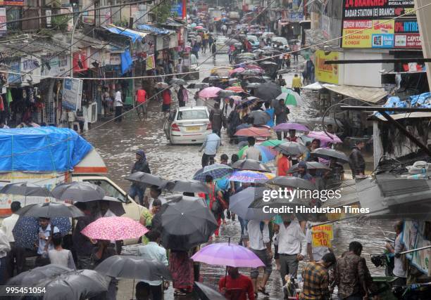People wade through water-logged on streets after heavy rainfall, at Dadar, on July 9, 2018 in Mumbai, India. Indias financial capital and its...