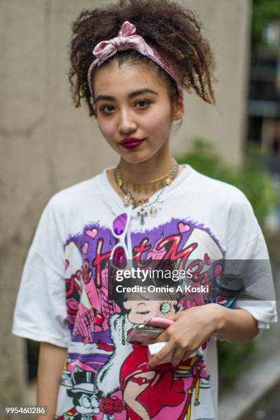 Chika, a shop clerk at PIN NAP, wearing all vintage, pink hair tie, a Betty Boop t-shirt, zebra print pants, baby blue platform sneakers, and rosary...