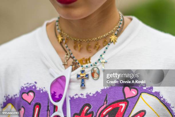 Chika, a shop clerk at PIN NAP, wearing all vintage, pink hair tie, a Betty Boop t-shirt, zebra print pants, baby blue platform sneakers, and rosary...