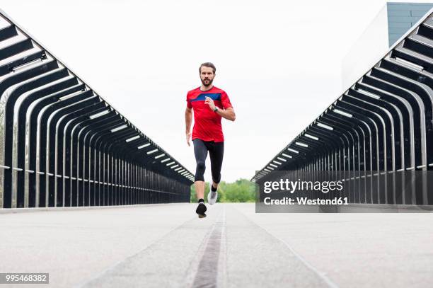 man running on a bridge - acercarse fotografías e imágenes de stock